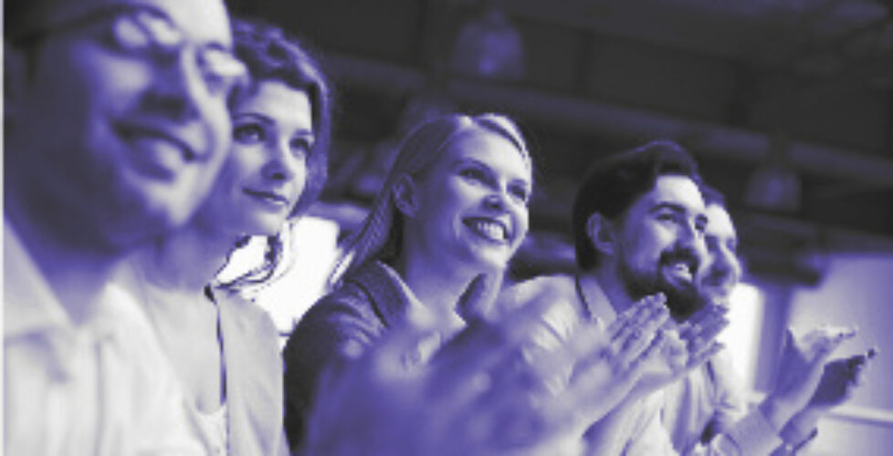 Photo of happy business partners applauding at conference